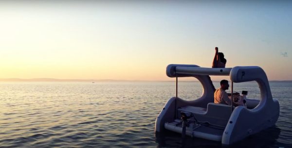 A couple sailing with the E-Trinity 2 boat and watching the sunset