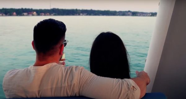 A couple hugging and having a romantic date while watching the sea in a boat